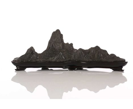 A Chinese carved and part polished stone brush rest, of mountain form with six peaks, on fitted wood stand, 22.4cmIn good con