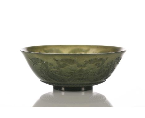 A Mughal style spinach jade bowl, with slightly everted rim, the exterior carved in relief with scrolling foliate tendrils ab