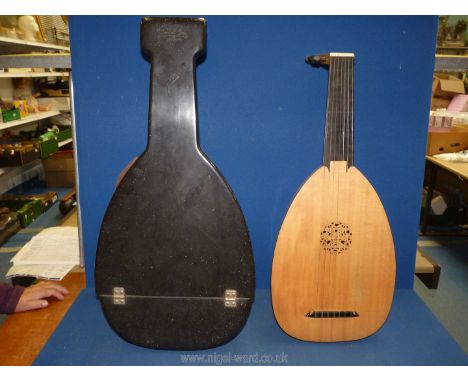 A Lute with seven strings, in hard carrying case, 28'' long.