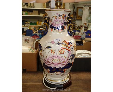 A Mason's lamp with wooden base and pink shade.