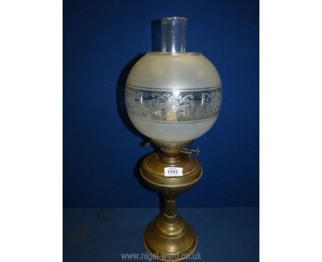 A brass based paraffin double burner oil lamp with clear chimney and a globular glass shade, 22" tall.