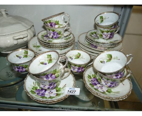 A ten piece Victoria Carlsbad Austria part tea set, hand painted with pansies and foliage with gilt rims, to include 10 cups,