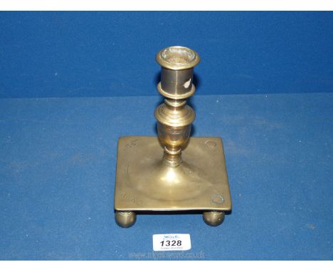 An early 17th century Spanish square base brass candlestick inscribed and with a date now obscured by an old repair;  old col