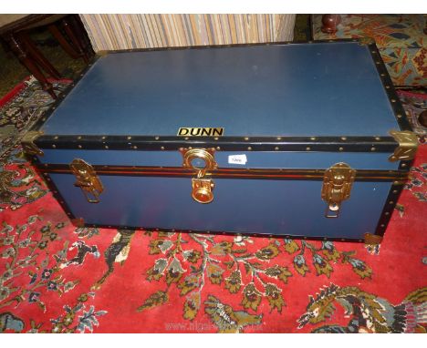 A  travel trunk in dark blue with studded borders and metal corners, 36'' wide x 20'' deep x 14'' high.