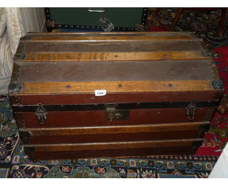 A large canvas and wood travel trunk with domed top and metal fastenings, 30" x 17" x 16 1/2", some damage.