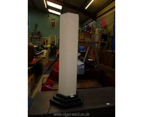 A contemporary floor Lamp having a triple step ebonised plinth and with a cream coloured hexagonal shade, 105 cm. high.