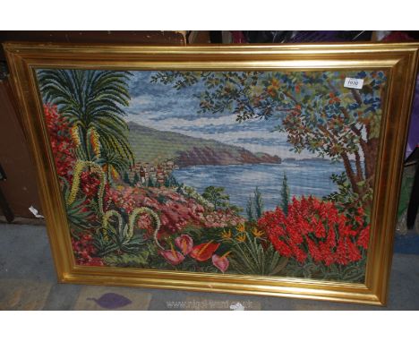 A tapestry of a cliff scene with shrubbery and flowers surrounding 27½" x 36".