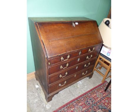 A Georgian Oak Bureau, the slope opening to reveal an interior with eight pigeon holes and seven drawers, the base with four 
