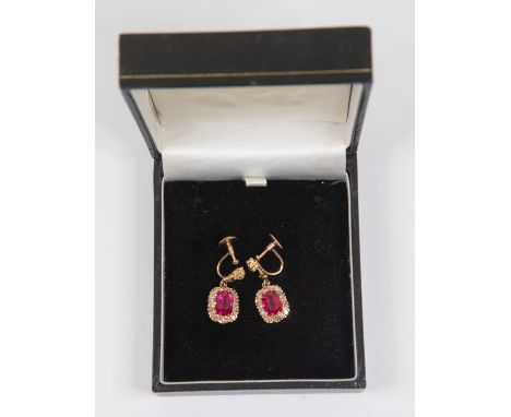 A pair of synthetic ruby and diamond cushion shaped drop cluster yellow gold earrings, the cushion shaped cluster drops compr