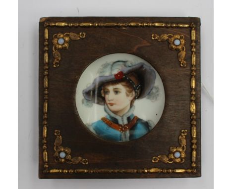 A porcelain hand painted miniature portrait, having a wooden surround and gilt mounts. Size 10.5cm.square. Condition: Some we