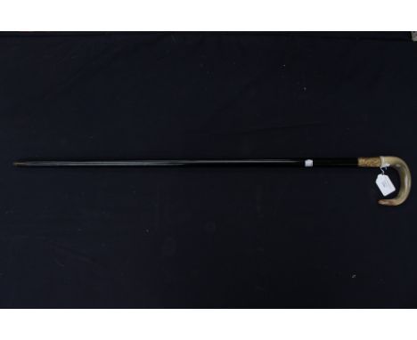 An early 20th Century ebonised wooden walking stick with horn curved handle and 18ct gold band