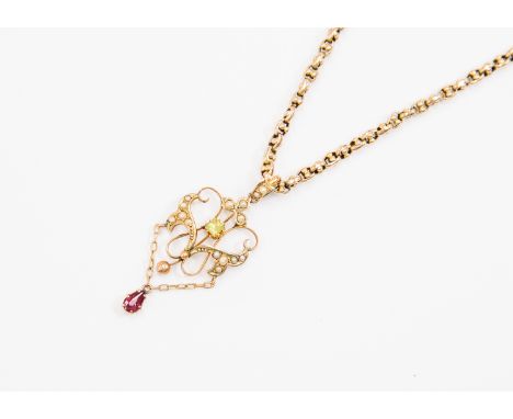 An Edwardian and 9ct gold pendant, open scroll design set with seed pearl decoration, centrally set peridot with a chain link