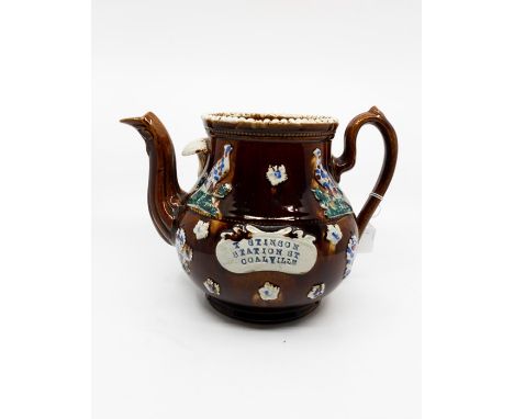 A Measham 'Barge' teapot with the name "T Stinson Station Road Coalville" stamped on an applied ceramic plaque, handle of pot