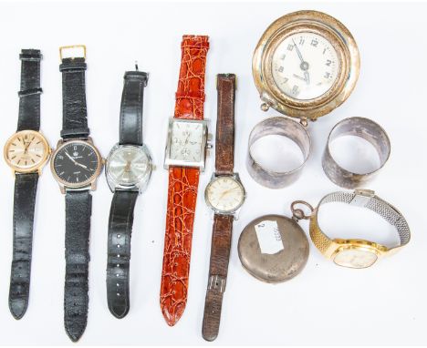 A group of assorted wristwatches together with a silver Mercedes travel clock, two silver napkin rings and a silver pocket wa