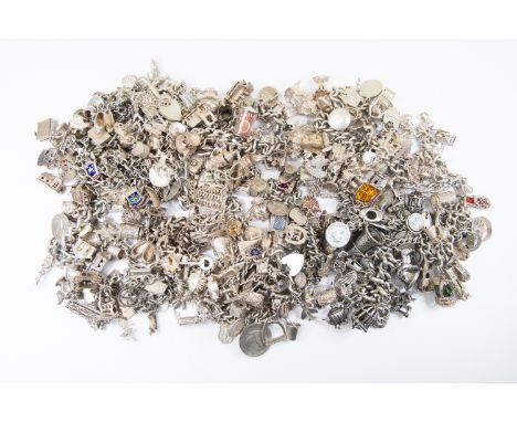 A collection of twenty four silver charm bracelets comprising various silver and white metal antique versions and contemporar