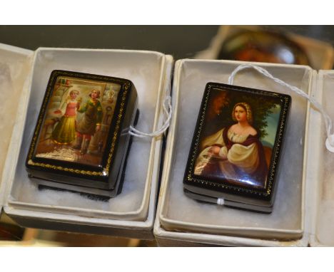 Two Pegockuno Russian black lacquered papier mache miniature patch boxes, of sarcophagus form, one painted depicting a young 