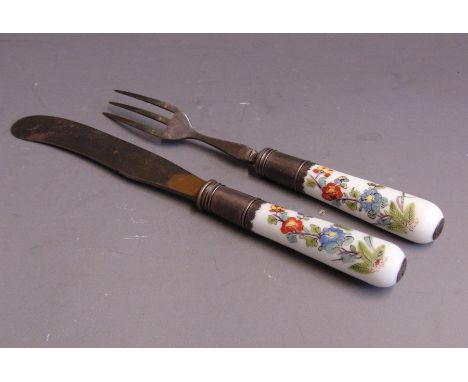 A Meissen knife and fork with porcelain handles set in white metal mounts, the handles are painted in the Kakiemon style with