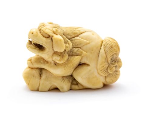 A 19th Century oriental ivory netsuke, carved&nbsp; as a Foo dog upon a rock, width 4cm