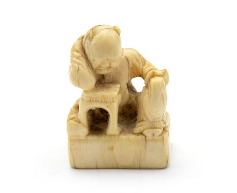 A 19th Century oriental ivory netsuke, carved as a disgruntled man with his arm on a table, height 4cm