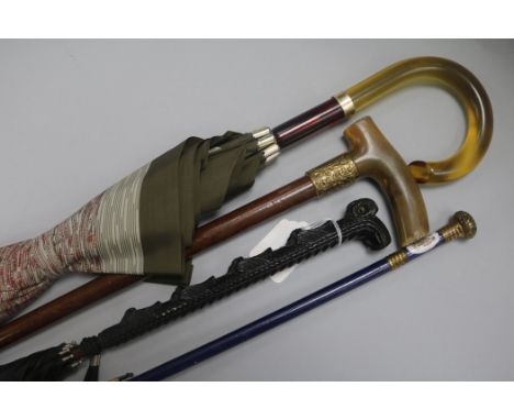 Three umbrellas, one with owl handle and a horn handled walking stick
