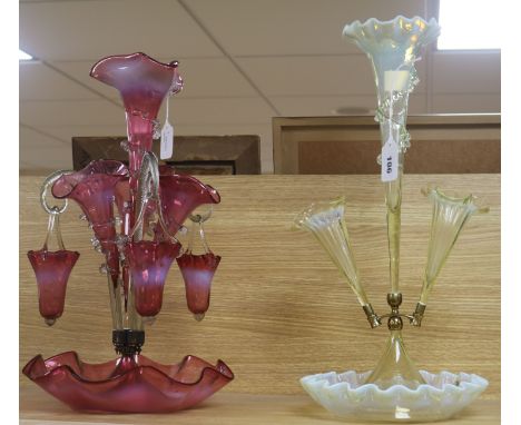 A Victorian cranberry glass epergne and a pale yellow vaseline glass epergne, the cranberry epergne fitted four flutes and th