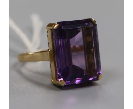 A yellow metal and emerald cut amethyst dress ring, size O.