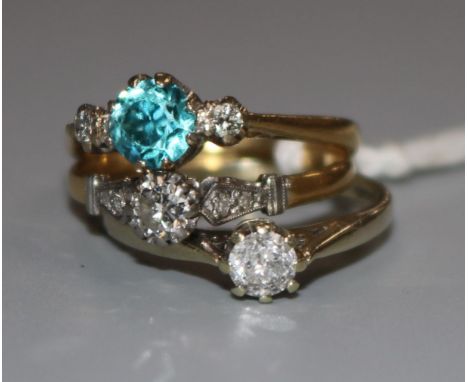 An 18ct gold, blue zircon and diamond three stone ring and two other diamond rings, one 18ct and one 9ct.