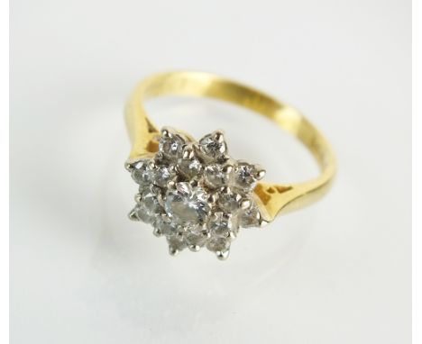 An 18ct gold graduated diamond cluster ring, designed as a central brilliant cut diamond within an inner surround of eight br