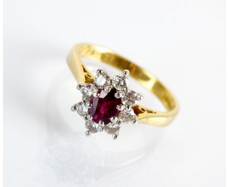 An 18ct gold ruby and diamond oval cluster ring, designed as a central oval mixed cut ruby within a surround of eight brillia
