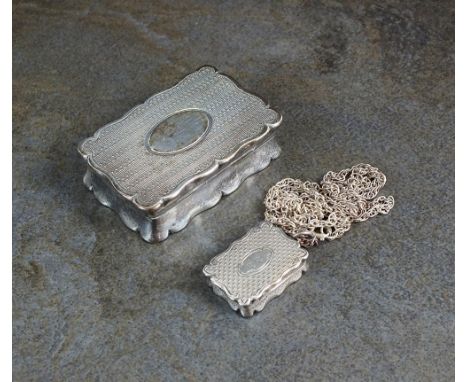 An Edwardian silver snuff box, William M Hayes, Birmingham 1902, of shaped rectangular engine turned form, together with a Vi
