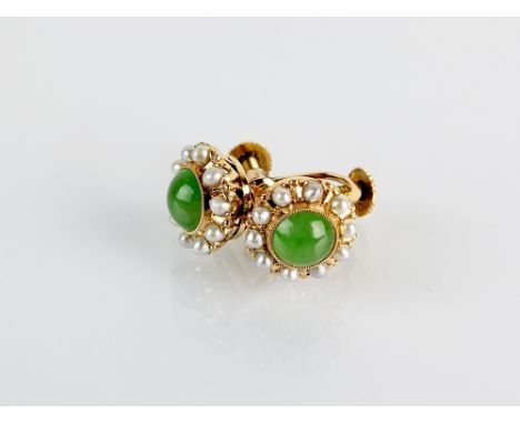 A pair of jade and seed pearl floral cluster earrings, each designed as a central round cabochon jade collet set within a bor