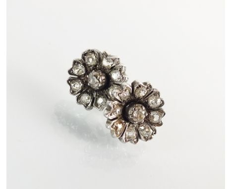 A pair of late 19th/early 20th century diamond floral cluster earrings, each designed as a central old cut diamond claw set w