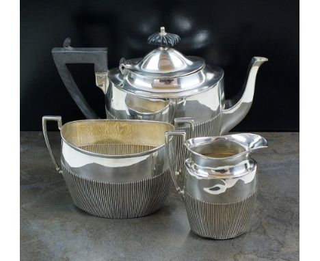 An Edwardian three piece silver tea service, James Dixon & Sons Ltd, Sheffield 1902, each piece of oval half reeded form, com