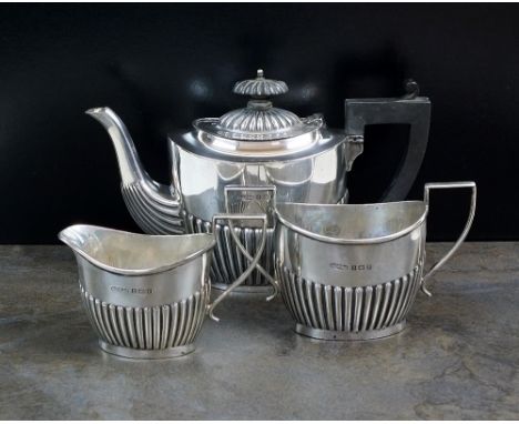 A three piece silver tea service, G F Westwood & Sons, Birmingham 1914, each piece of oval half reeded form, comprising; a te