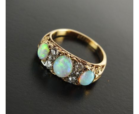 A late 19th century opal and diamond cluster ring, designed as three graduated oval cabochon opals interspersed with six old 