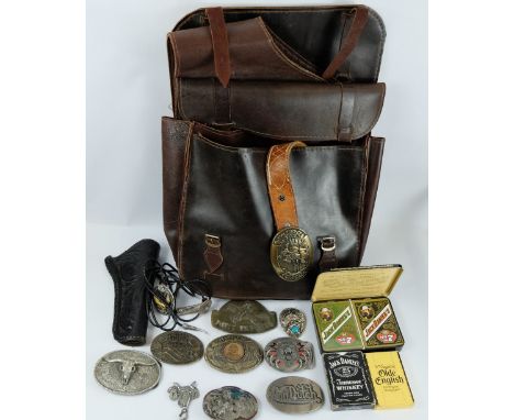 A collection of wild west cowboy metal belt buckles, badges, playing cards, leather horse saddle bags, leather gun holsters, 
