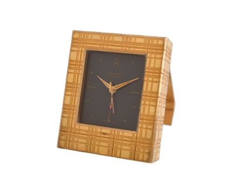 Hermes,   Gilt metal travel alarm clock Movement: Swiss manual wind, 17 jewels   Case: Gilt metal, snap case back   Size: 38m