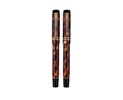 Parker, Duofold, two amber check fountain pens, the caps with gilt arrow clips and double cap bands, the medium and broad nib
