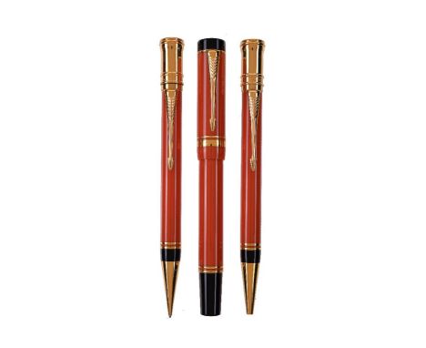 Parker, Duofold, an orange fountain pen, ball point pen and propelling pencil, the fountain pen cap with gilt arrow clip and 