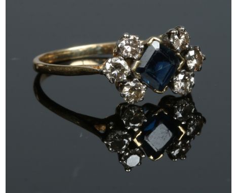 An antique yellow metal cluster ring set with a square cut sapphire and six diamonds. Size R.   Condition Report. To be used 