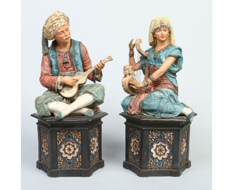 A pair of 19th century Austrian painted terracotta figures formed as a Turkish guitar player and his companion. Each seated o