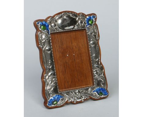 An Art Nouveau silver eizel photograph frame by Horton & Allday. Decorated in relief with stylized poppies and with later blu