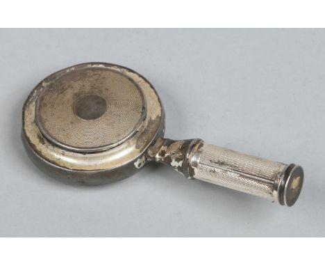 A silver plated musical powder compact with a lipstick compartment concealed in the handle and decorated with engine turned e
