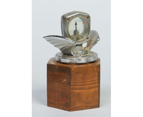 A vintage chrome car radiator cap mascot raised on a wooden plinth. Formed with a pair of wings and housing a calormeter. Mak