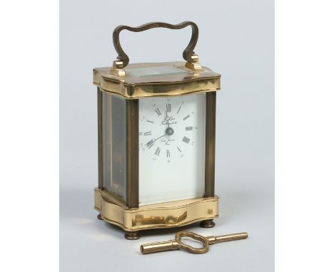 A French brass cased serpentine carriage clock. With enamel dial having Roman numeral markers and Arabic minute markers, sign