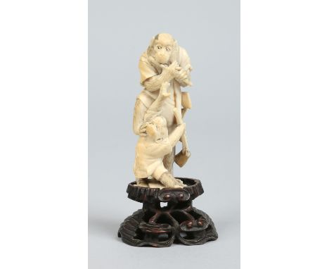 A Japanese Meiji period carved ivory okimono on hardwood plinth formed as a pair of monkeys, one playing a flute, total heigh