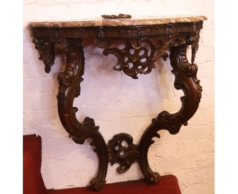 A 19th century Flemish Rococo style carved walnut and marble top console table of serpentine form, 84cm wide.