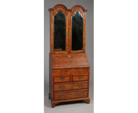An antique Queen Anne style figured walnut bureau bookcase of slender proportions. The double dome topped bookcase section ha