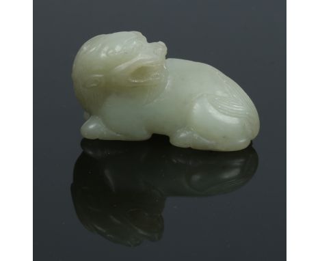 A late 19th century Chinese carved celadon jade model of a recumbent Pixiu. Laying square upon its paws and with its head tur
