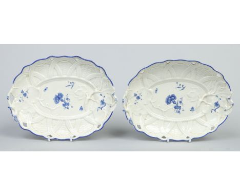 A pair of Worcester basket shaped dishes moulded with twin branch handles, leaves and tendrils. Painted in dry blue with gill